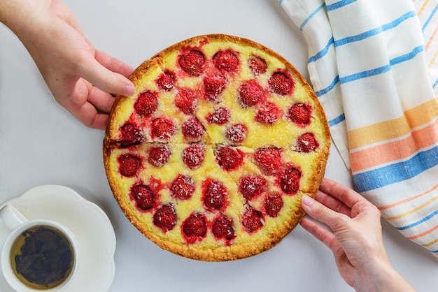 Le mani prendono fette di torta fatta in casa alla fragola.