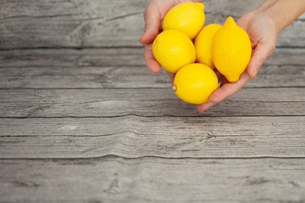 Le mani stanno tenendo i limoni gialli. Vitamine.