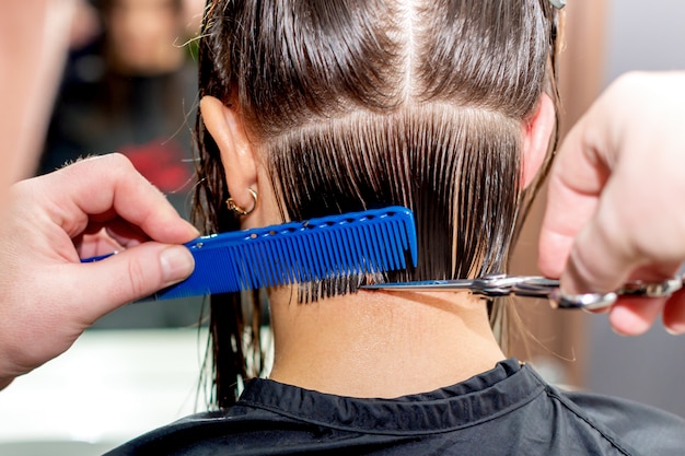 Le mani taglia i capelli della donna.