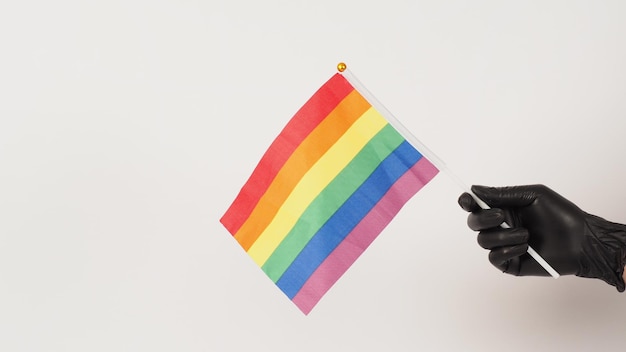 Le mani tengono una lavagna cinematografica o un ciak e una bandiera arcobaleno Le mani indossano guanti in lattice nero
