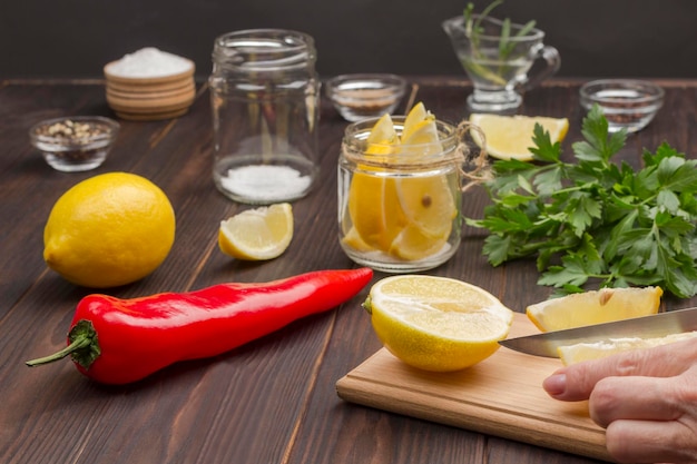 Le mani tritano un limone sul tagliere Limone in barattolo Alimento fermentato per rafforzare l'immunità