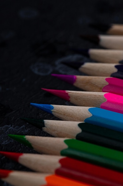 le matite colorate si trovano su uno sfondo scuro
