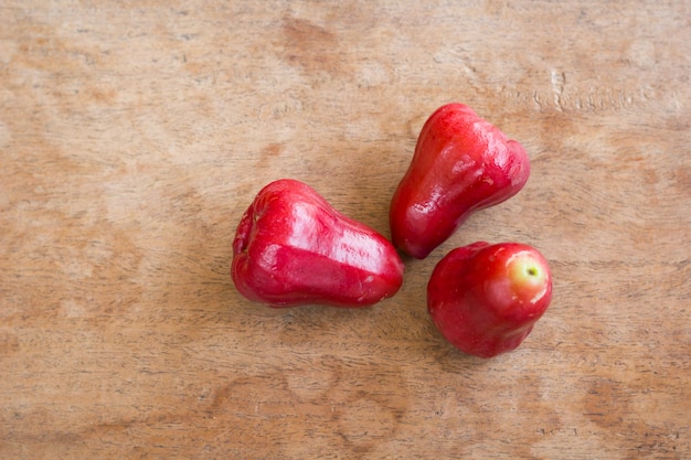 Le mele rosa su tavola di legno.