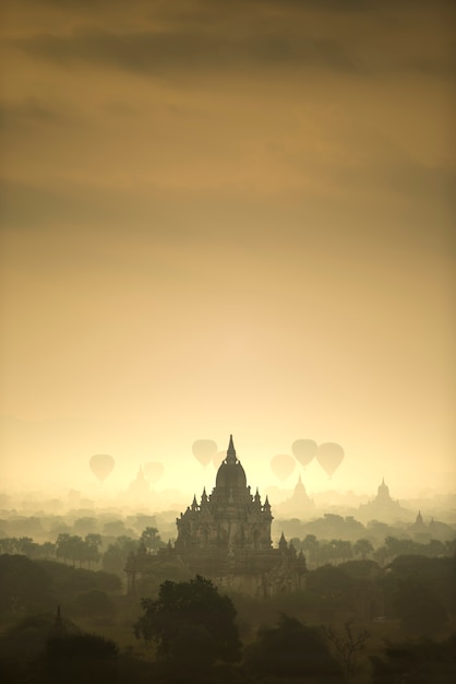Le mongolfiere di scena di alba sorvolano il campo della città antica della pagoda in Bagan Myanmar.