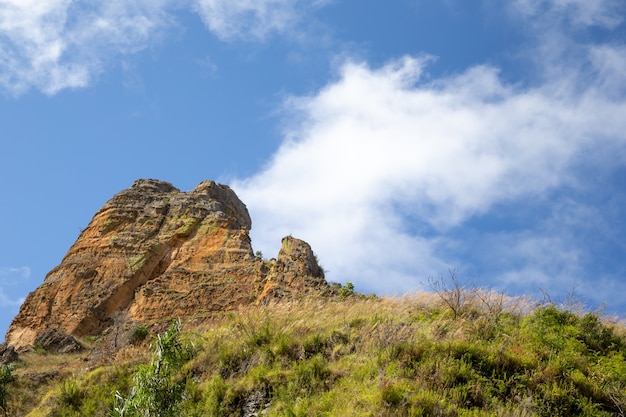 Le montagne ricoperte di piante e un cielo azzurro con piccole nuvole