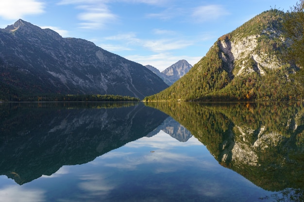 Le montagne si riflettono nell'acqua di un lago di montagna. La foto è stata scattata nelle Alpi a Plansee in Austria