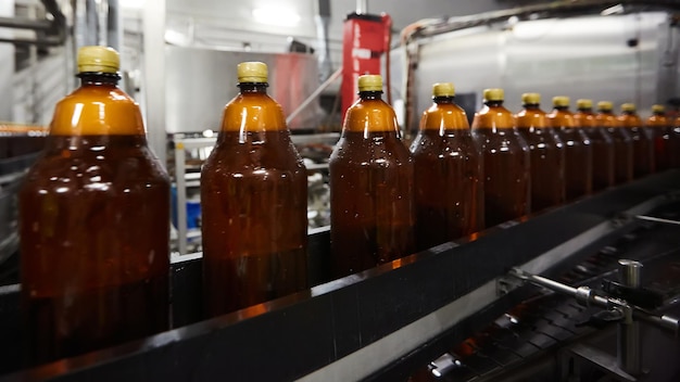 Le nuove bottiglie di plastica sul nastro trasportatore della fabbrica di birra potabile Processo di produzione dell'acqua potabile DOF poco profondo Messa a fuoco selettiva