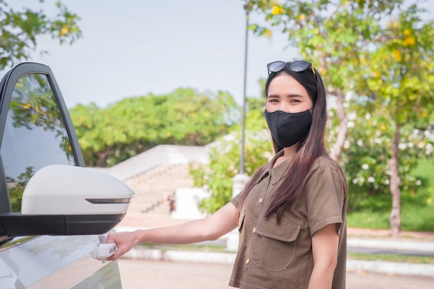 Le nuove donne normali indossano una maschera proteggono il coronavirus covid19 quando viaggiano in auto