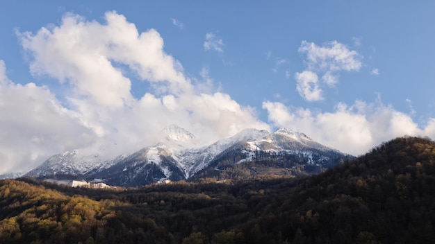 Le nuvole cumulus si muovono sulle cime innevate di alte montagne