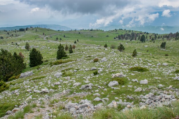 Le nuvole piovose si avvicinano al prato verde della montagna.