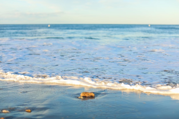 Le onde baciano dolcemente la spiaggia sabbiosa mentre le persone si rilassano catturando la serenità e la gioia della vacanza al mare