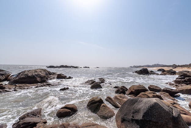 Le onde bianche battono contro le rocce nere