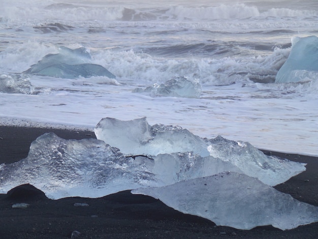 Le onde che colpiscono gli iceberg sulla spiaggia di sabbia nera, Islanda del sud