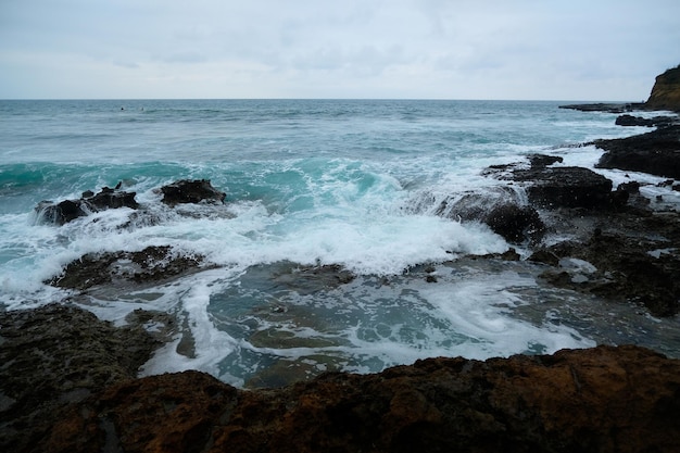 Le onde del mare si infrangono sugli scogli in una giornata tempestosa