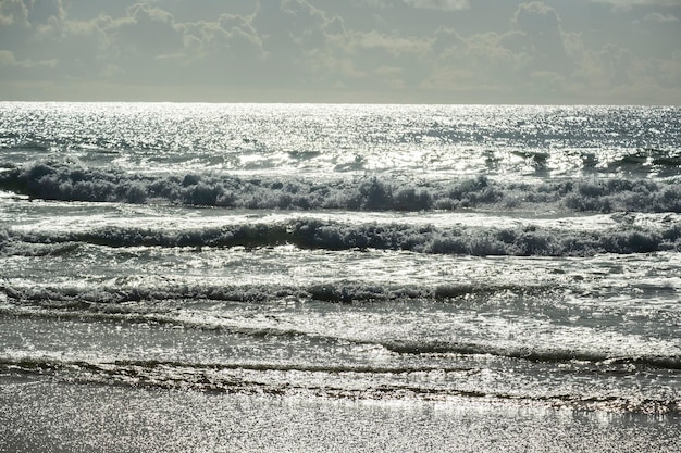 Le onde del mare viste al tramonto riflettono la luminosità del sole