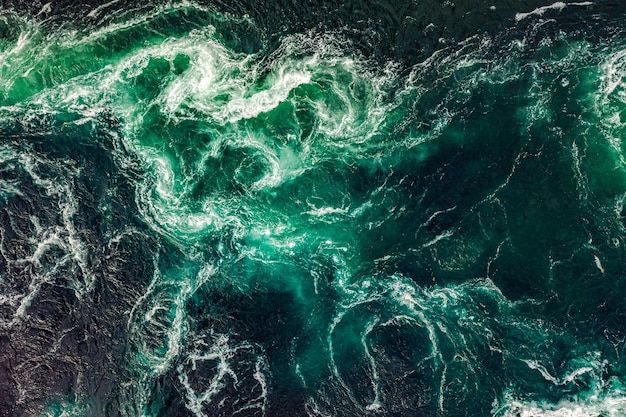 Le onde dell'acqua del fiume e del mare si incontrano durante l'alta e la bassa marea. I vortici del vortice di Saltstraumen, Nordland, Norvegia