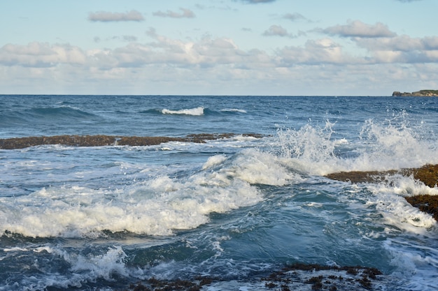 Le onde dell'oceano colpiscono la costa rocciosa