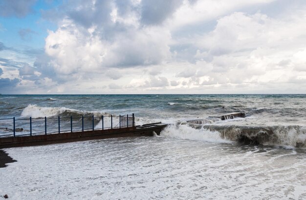 Le onde della tempesta rotolano sul frangiflutti