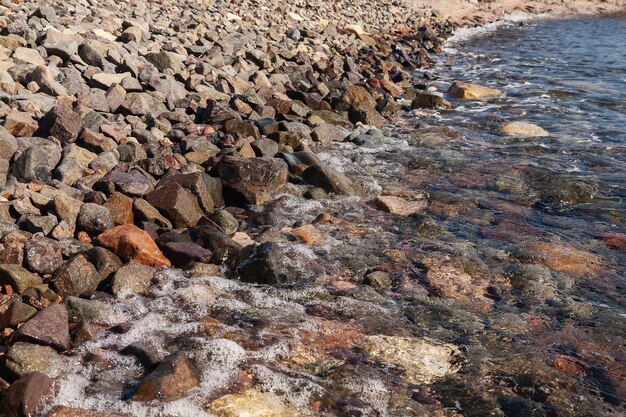 Le onde rotolavano sulla riva con ciottoli