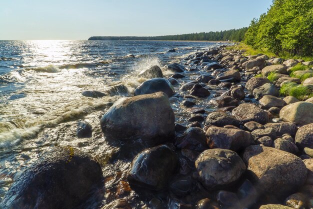 Le onde si infrangono sui massi sulla riva del Lago Ladoga. Vidlitsa. Carelia.