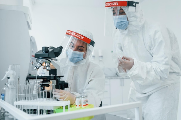 Le operatrici mediche in uniforme protettiva lavorano sul vaccino COVID19