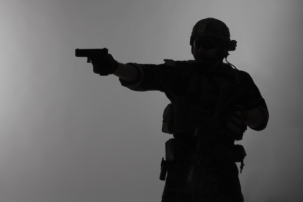 Le operazioni speciali del Corpo dei Marines degli Stati Uniti comandano il raider Marsoc con la pistola di mira dell'arma. Sagoma di operatore speciale marino sfondo grigio