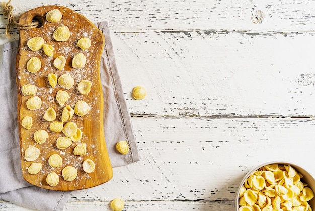 Le orecchiette fresche sono pasta italiana tipica della Puglia Pasta cruda sul tagliere con lo spazio della copia