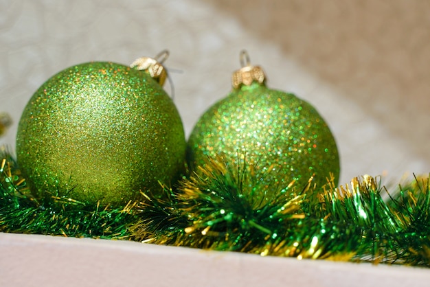 Le palle di Natale lucide verdi giacciono su orpelli verdi, da vicino