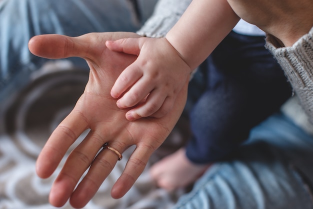 Le palme di un grande uomo e di un bambino piccolo l&#39;una sull&#39;altra. Amore e protezione del Padre. Successione di generazioni