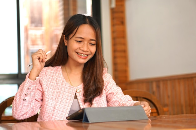 Le parentesi graffe della donna asiatica guardano il computer Sono contento che i risultati aziendali siano redditizi