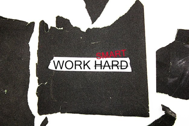 Le parole HARD WORK sono barrate e sostituite con SMART su uno sfondo di carta vetrata dura Cambia HARD WORK in SMART Il concetto di sostituire il duro lavoro con smart