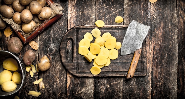 Le patate a fette su una vecchia tavola di legno