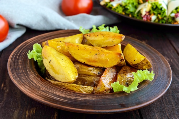 Le patate al forno sono "a casa" in una ciotola di argilla sul tavolo di legno