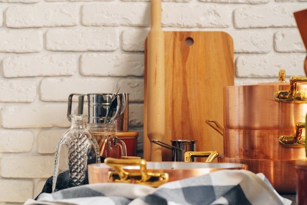 Le pentole di rame con gli utensili di legno della cucina si chiudono su