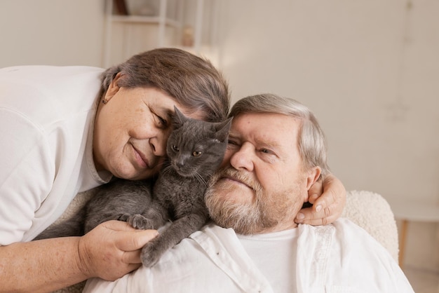 Le persone anziane si prendono cura dei gatti e se li godono a casa