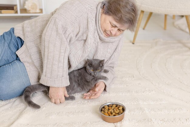 Le persone anziane si prendono cura dei gatti e se li godono a casa