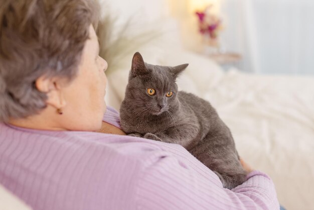 Le persone anziane si prendono cura dei gatti e se li godono a casa