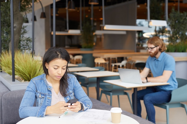 Le persone che lavorano con gadget nella caffetteria