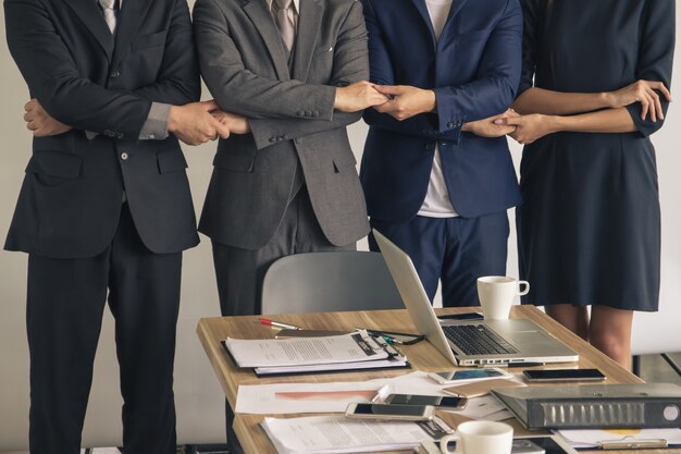 Le persone di affari si tengono per mano, stanno in una fila, concetto di lavoro di squadra.