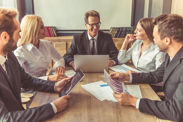 Le persone in giacca e cravatta discutono di affari, usando gadget.