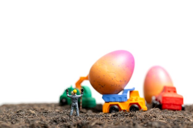 Le persone in miniatura lavorano alle uova di Pasqua per il giorno di Pasqua