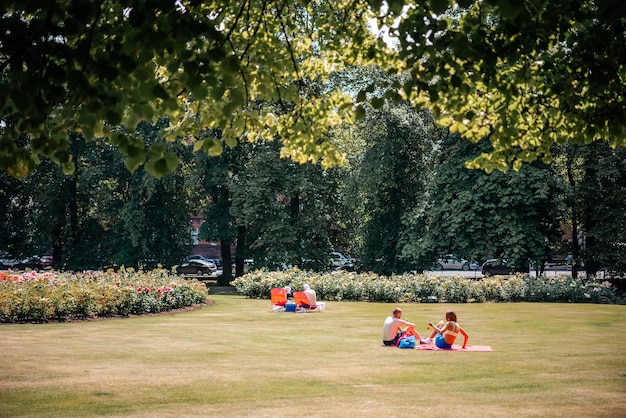 Le persone prendono il sole sull'erba nel parco nel Regno Unito