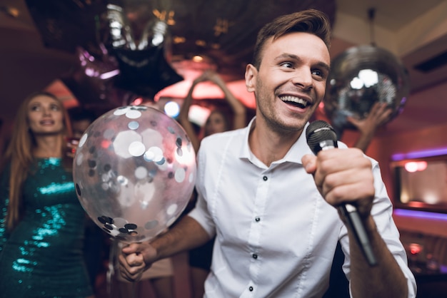 Le persone si divertono in una discoteca e cantano al karaoke