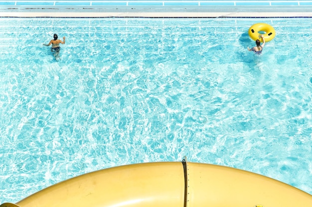 Le persone si rilassano su anelli di gomma gonfiabili in piscina con acqua cristallina