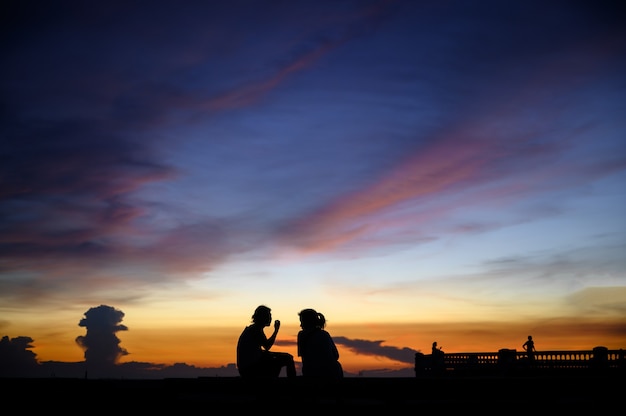 Le persone silhouette al mare con il cielo al tramonto