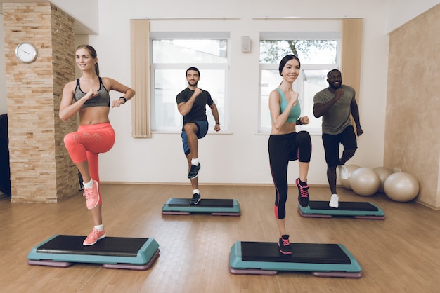 Le persone sono impegnate nel fitness nella moderna palestra con gli amici