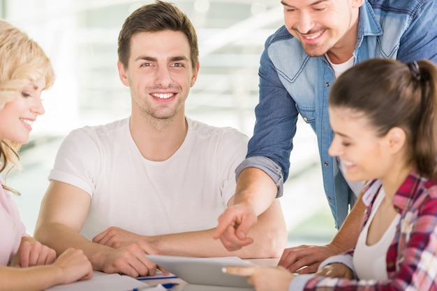 Le persone sono sedute al tavolo e utilizzano la tavoletta digitale.