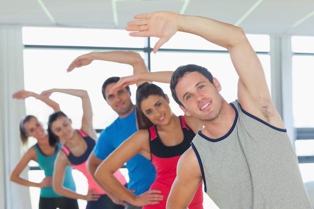 Le persone sportive facendo esercizio di fitness potenza a lezione di yoga