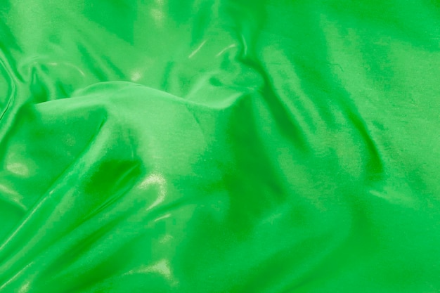 Le pieghe del tessuto di seta verde svolazzanti al vento