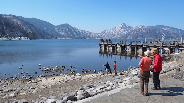 Le più vecchie coppie che esaminano la bella vista mentre i bambini che giocano vicino al lago